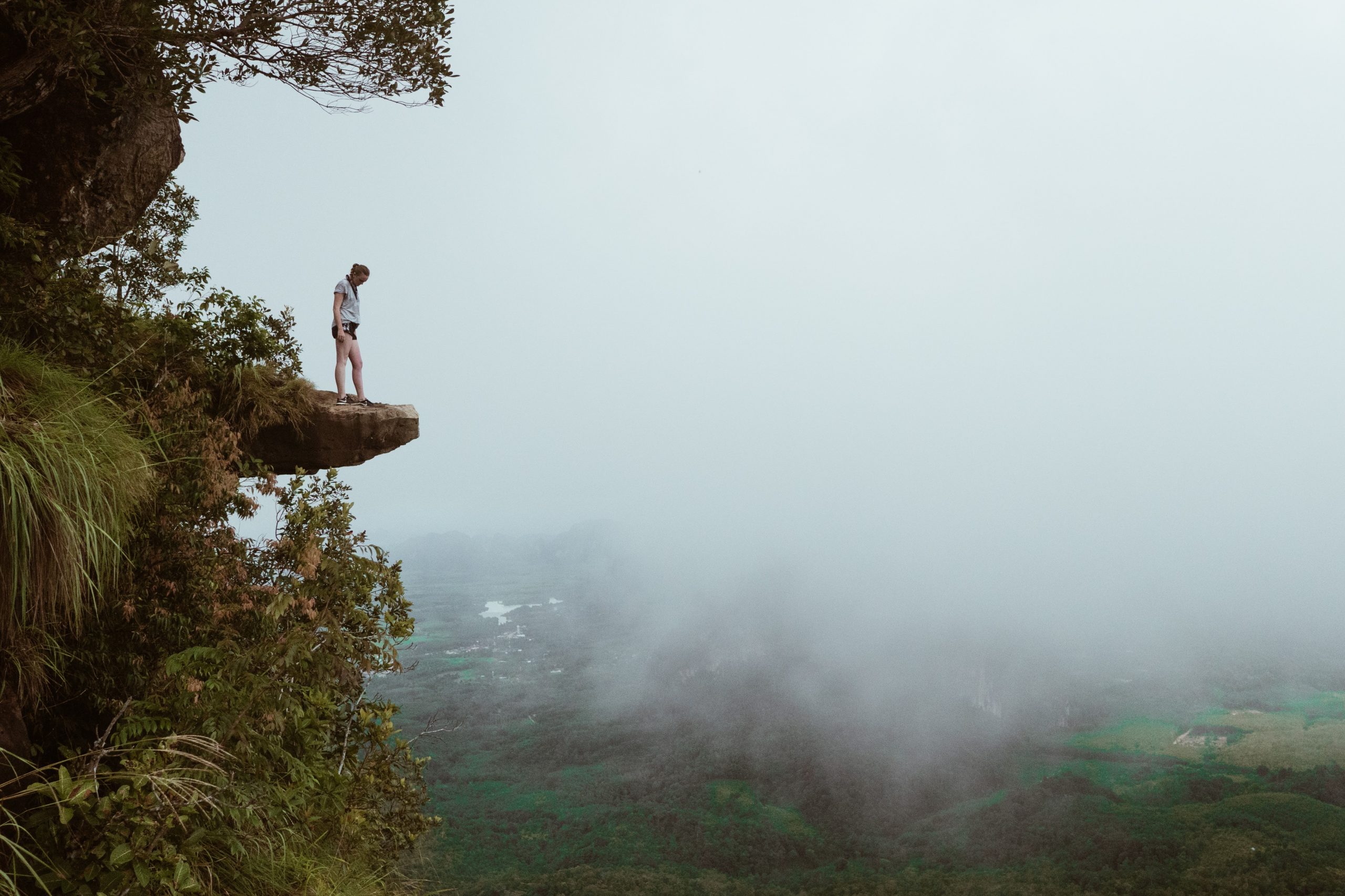 person standing on mountain cliff